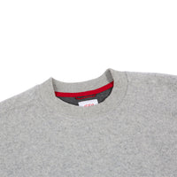 General detail of men's global sweater in gray showing crew neck hem.