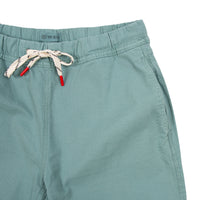 General front detail shot of Topo Designs Women's Dirt Pants in Sage green showing drawstring waist and hand pockets.