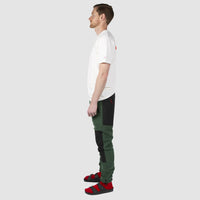 Side model shot of Topo Designs men's fleece pants in "forest / black"