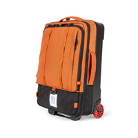 Topo Designs Global Travel Bag Roller durable carry-on convertible laptop backpack rolling suitcase in "Clay" orange.