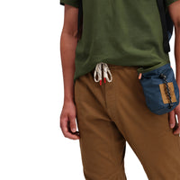 Front model shot of Topo Designs Men's Dirt Pants 100% organic cotton drawstring waist in "Dark Khaki" brown.