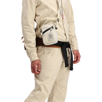 Front detail model shot of Topo Designs Men's Dirt Pants 100% organic cotton drawstring waist in "Sand" white