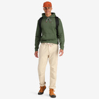 Front model shot of Topo Designs Men's Dirt Pants 100% organic cotton drawstring waist in "Sand" white show on "charcoal" & "brick"