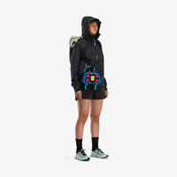 General shot of Topo Designs Women's Global Jacket lightweight packable 10k waterproof rain coat in recycled black polyester on model.