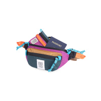 Open main compartment view of Topo Designs Mountain Waist Pack in lightweight recycled "Botanic Green / Grape" nylon.
